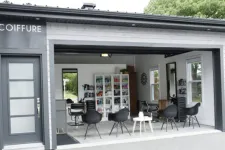 Home garage turned into a lovely professional hair salon with a waiting area, 2 hair styling stations, and hair products storage space.