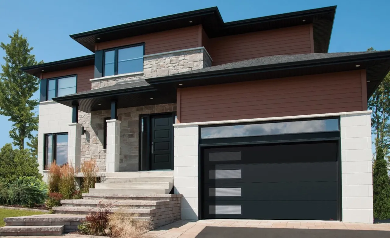 Brick house in shades of beige with brown vinyl siding and a square roof, paired with a Flush design double garage door in Black.