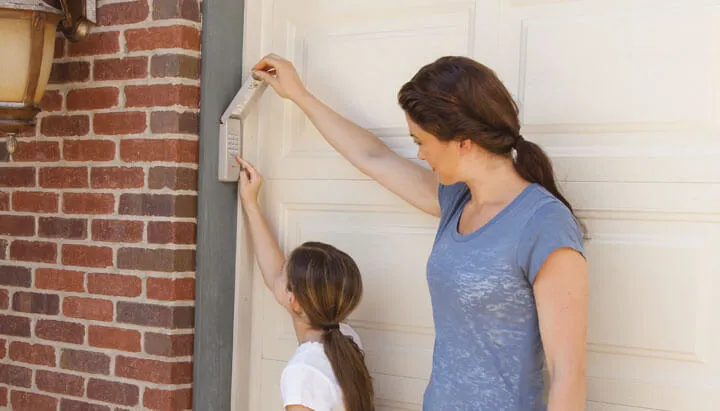 A mom and her daughter are going to the house from the garage. We can see that the garage door has secure door lock.