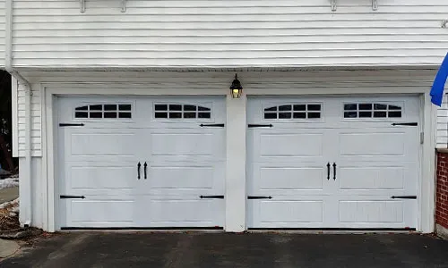 White house with North Hatley LP garage doors, 9' x 7', Ice White, windows with Double Stockton Arch Inserts