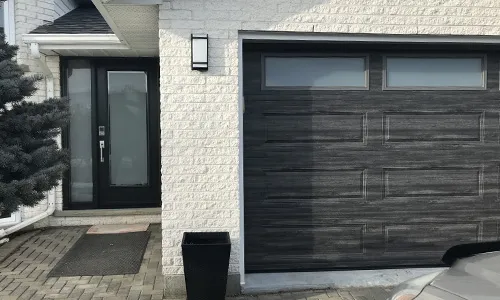 White brick house with Classic XL garage door, 16' x 7', Weathered Grey Faux Wood, White Sandblasted glass